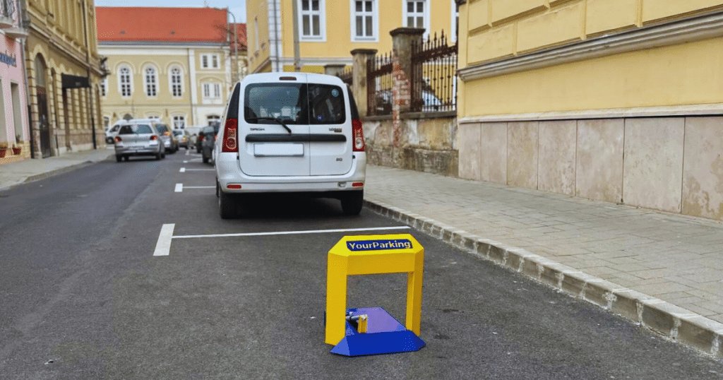 YourParking parkolásgátló az előtérben, parkoló autól a háttérben, autók, akik parkolóhelyet keresnek